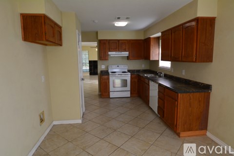 A kitchen with brown cabinets and a black counter top.