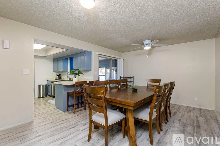 A dining room with a wooden table and chairs.