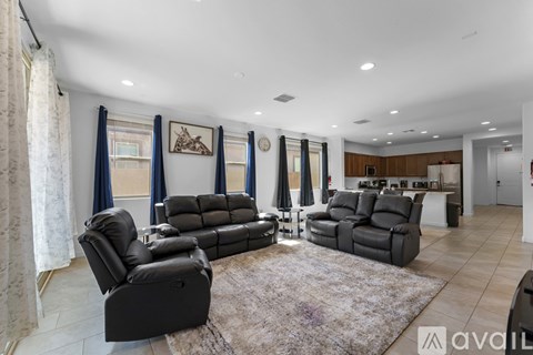 A living room with a large couch and a rug in the center.