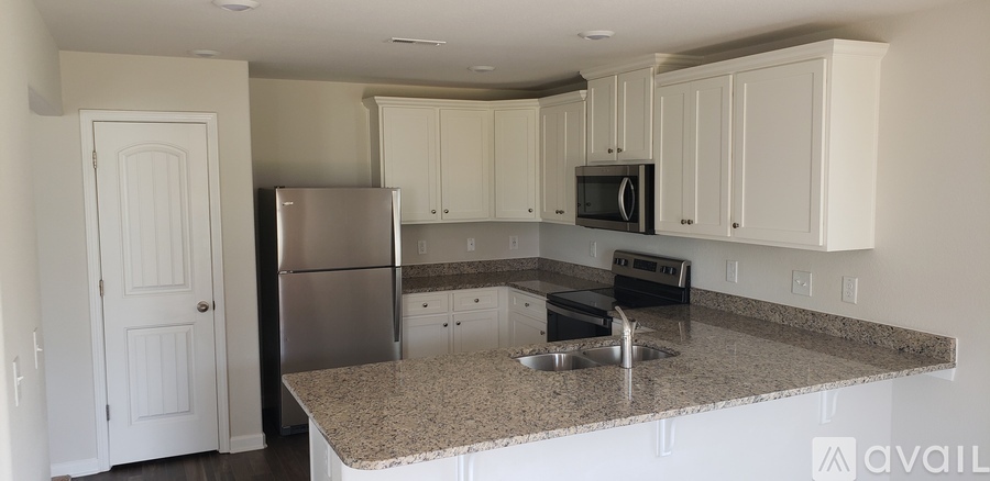 A kitchen with granite countertops and white cabinets.