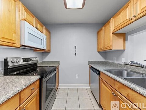 A kitchen with wooden cabinets and granite countertops.