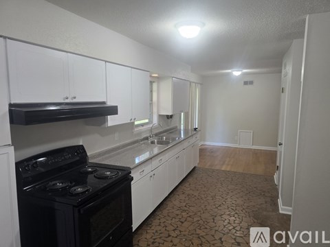 A kitchen with white cabinets and a black stove top oven.