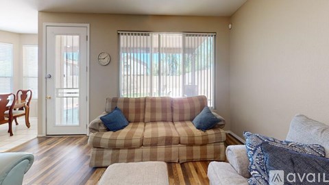 A living room with a striped couch and a wooden chair.