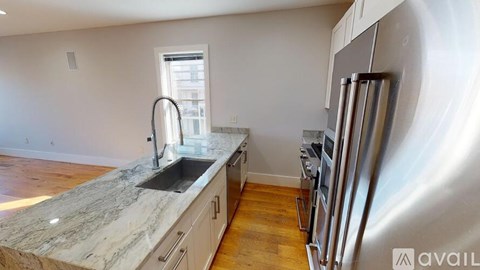 A kitchen with a marble countertop and stainless steel appliances.