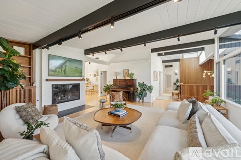 A living room with a fireplace and a painting on the wall.
