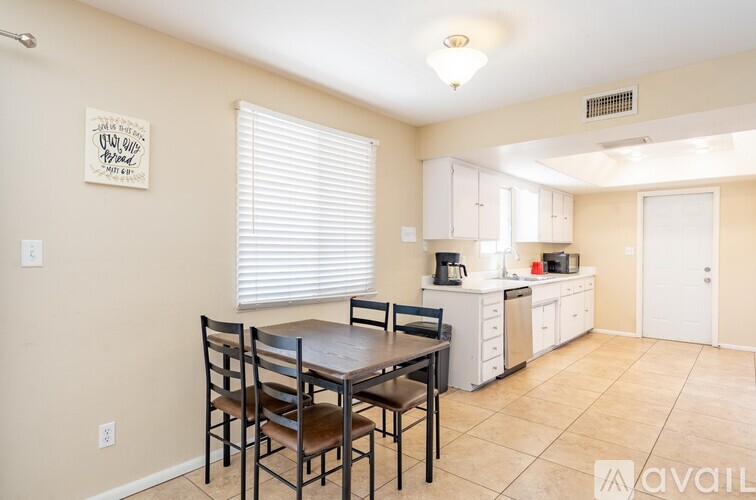 A kitchen with a table and chairs in front of it.
