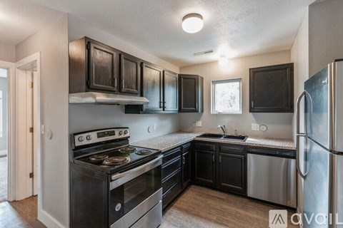 A kitchen with black cabinets and stainless steel appliances.