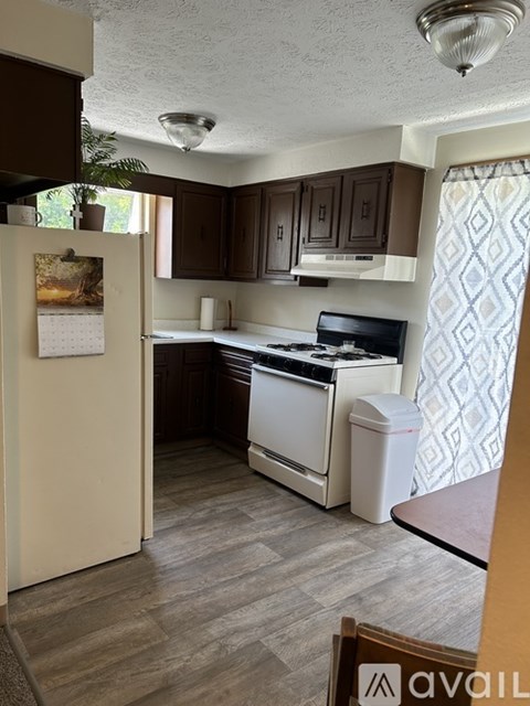 A kitchen with a white refrigerator and a white stove top oven.