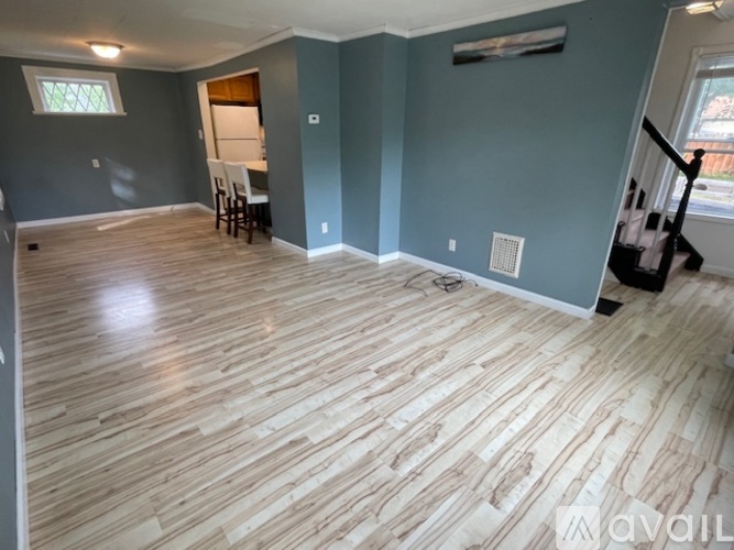 A room with wooden flooring and a window.