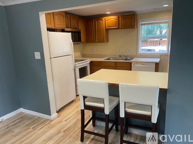 A kitchen with a white refrigerator and wooden cabinets.