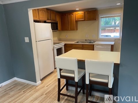 A kitchen with a white refrigerator and wooden cabinets.