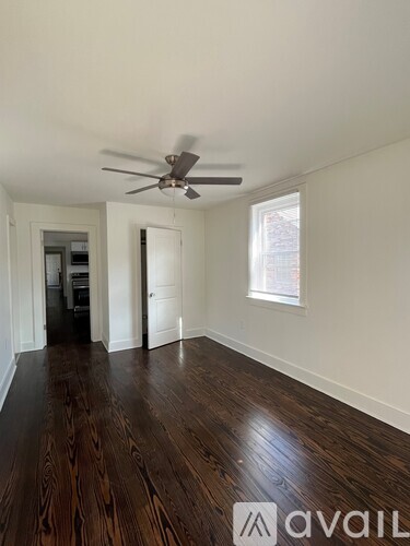 A bedroom with a bed, dresser, and a ceiling fan.