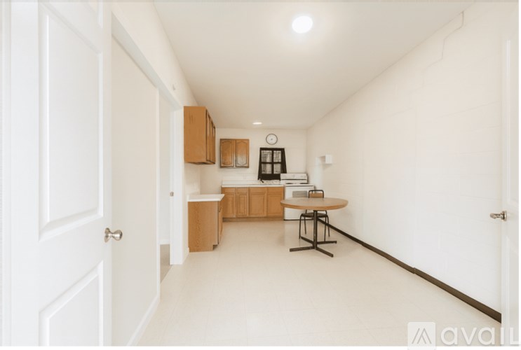 A kitchen with a refrigerator, cabinets, and a ceiling fan.