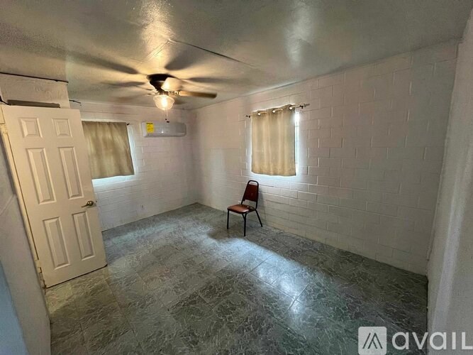 A room with a ceiling fan and a chair.