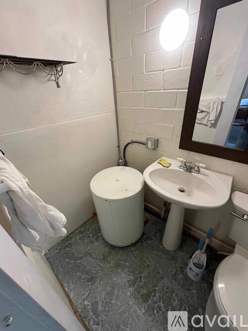 A bathroom with a toilet, sink, and mirror.