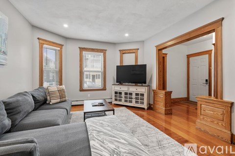 A living room with a grey couch and a television.