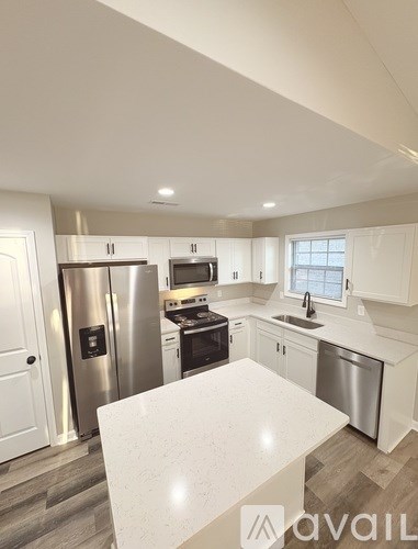 A modern kitchen with stainless steel appliances and white cabinets.