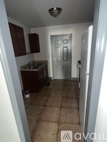 A kitchen with brown cabinets and a white door.