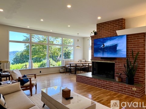 A living room with a fireplace and a television on the wall.