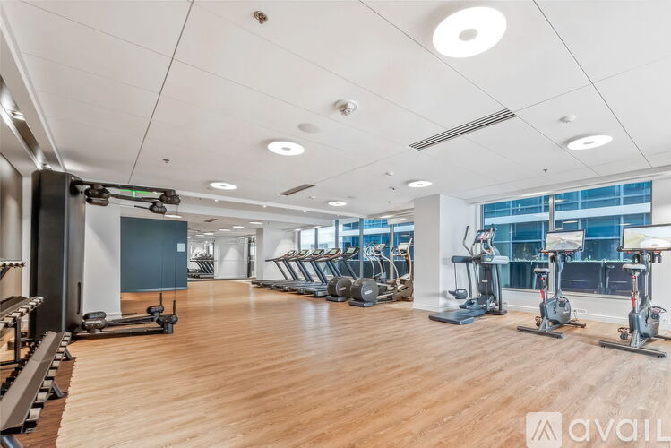 A gym with a variety of equipment including treadmills, weights, and exercise machines.