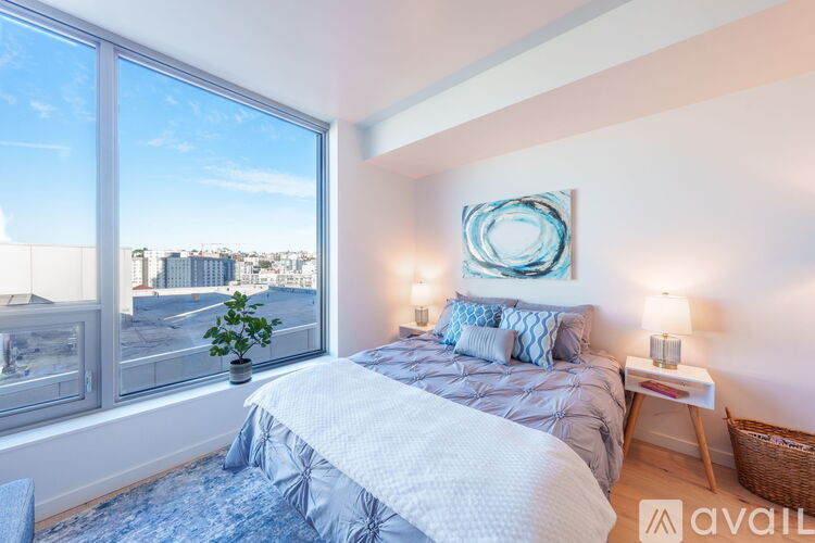 A bedroom with a large bed and a view of the city through the window.