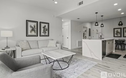 A modern living room with a grey sofa and a white coffee table.