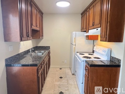 A kitchen with brown cabinets and a white refrigerator.