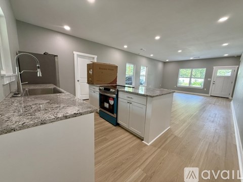 A kitchen with a granite countertop and wooden flooring is shown.