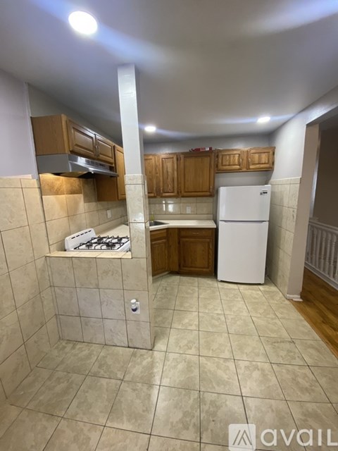 A kitchen with a white refrigerator and wooden cabinets.