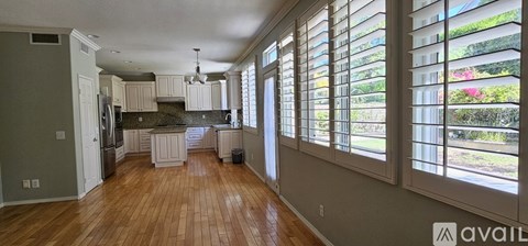 A kitchen with wooden floors and a large window.