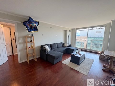 A living room with a grey couch and a blue star balloon.