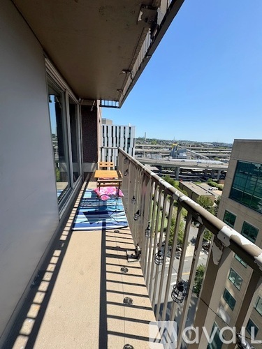 A balcony with a view of a pool and buildings.