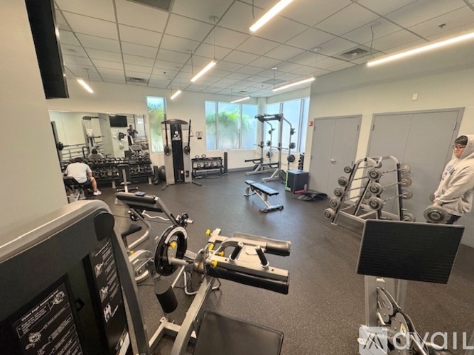 A gym with a variety of equipment including treadmills, weights, and exercise machines.