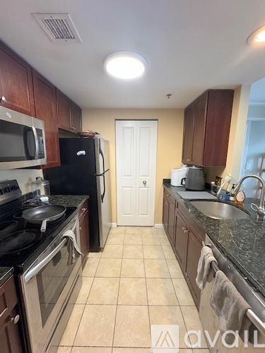 A kitchen with black appliances and wooden cabinets.