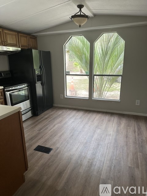 A kitchen with a black fridge and wooden cabinets.