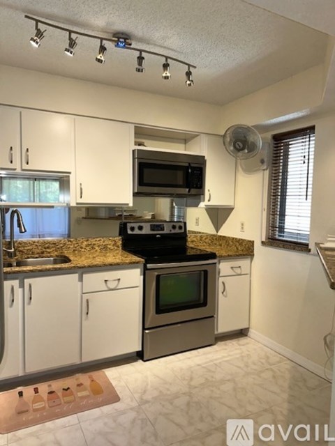 A kitchen with white cabinets and granite countertops.