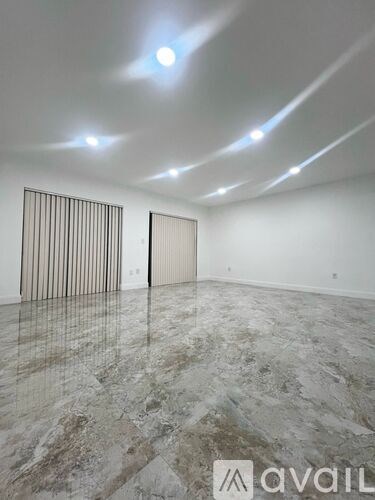 A spacious room with marble flooring and a logo that reads "avail" on the floor.