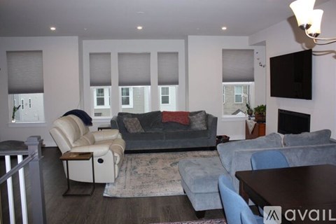 A living room with a grey couch and a white chair.