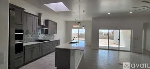 A modern kitchen with dark cabinets and a large island.