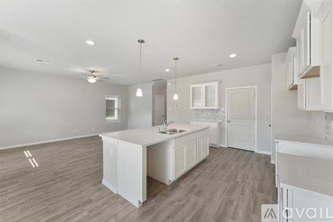 A spacious kitchen with white cabinets and a central island.