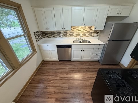 A kitchen with white cabinets and a black stove top.