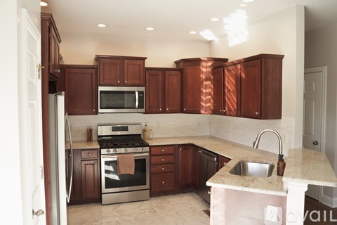 A kitchen with brown cabinets and stainless steel appliances.