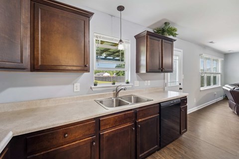 A kitchen with dark wood cabinets and a white countertop.