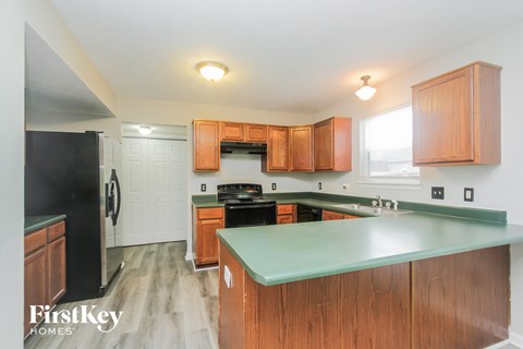 A kitchen with wooden cabinets and a green counter top.