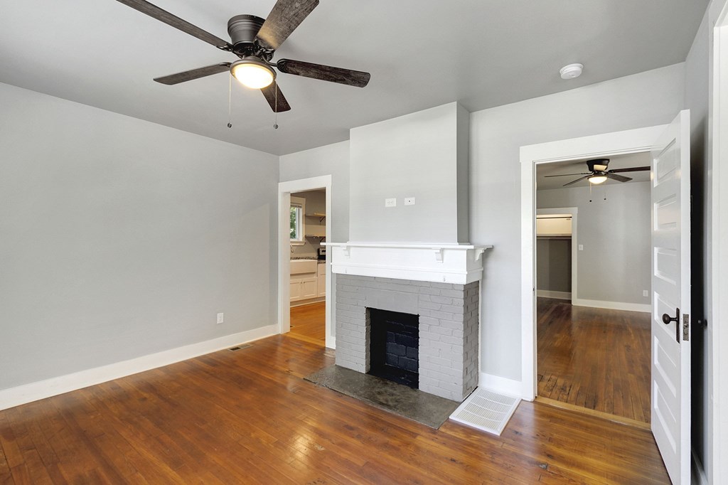 A room with a fireplace and a ceiling fan.