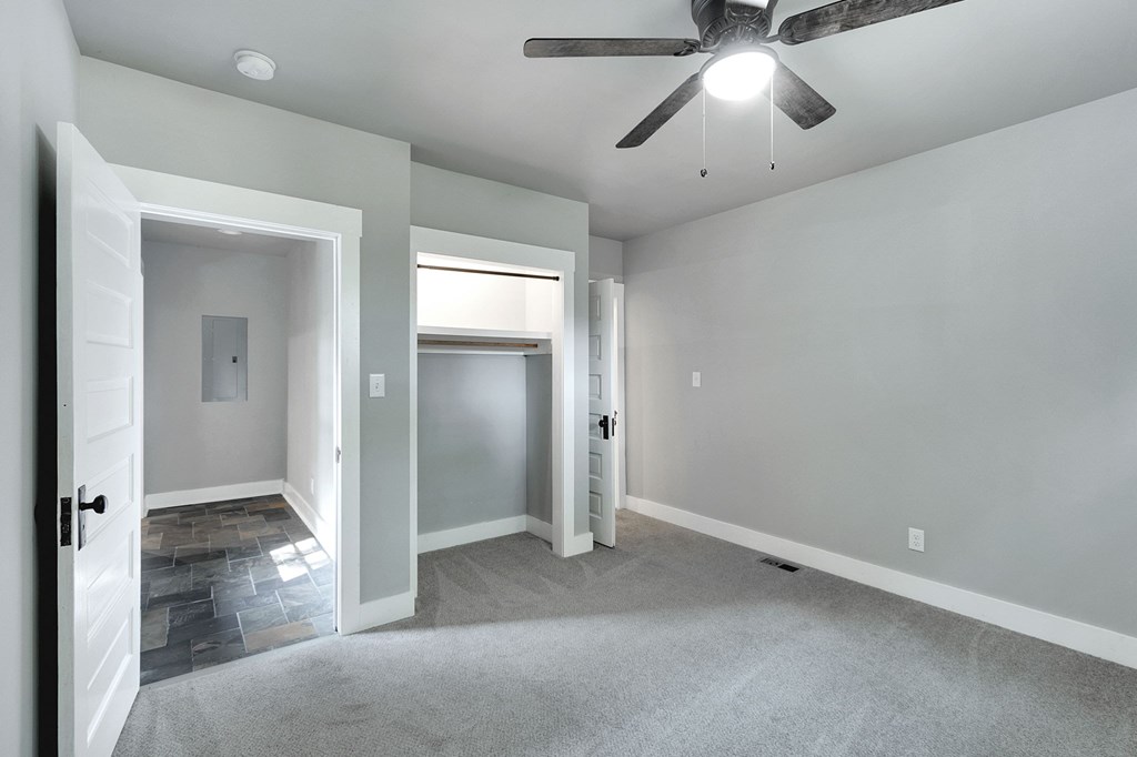 A room with a ceiling fan and a carpeted floor.