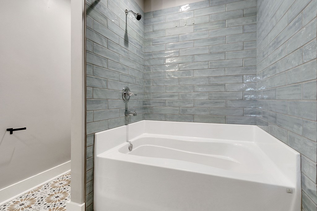 A white bathtub with a shower head and a shower head.