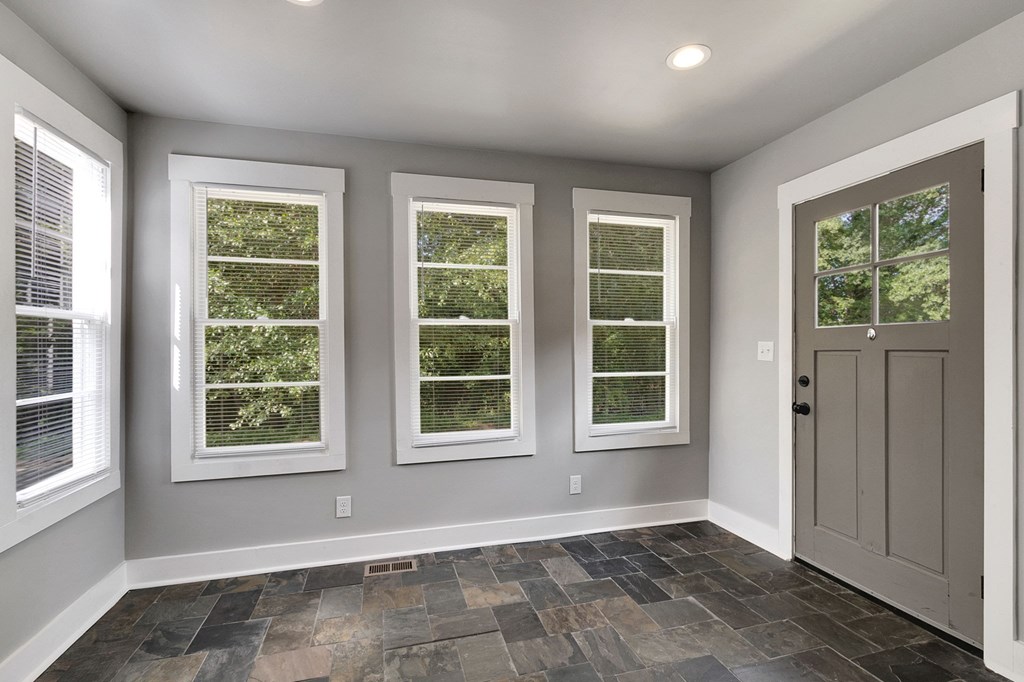 A room with three windows and a sliding door.