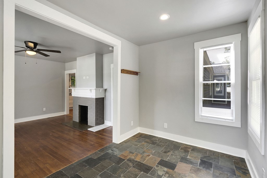 A room with a fireplace and a ceiling fan.