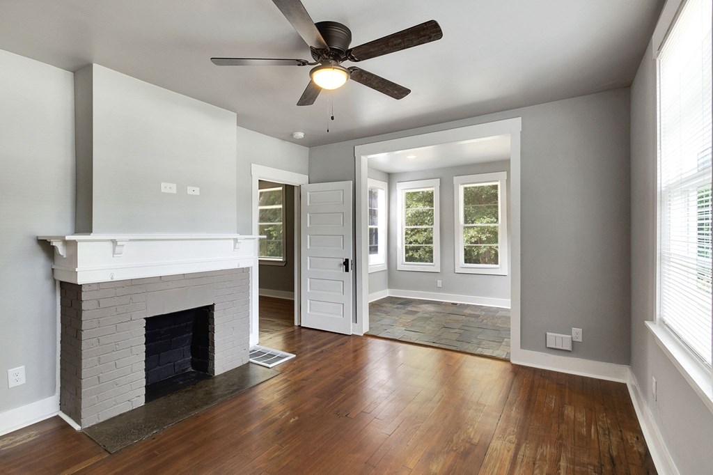 A room with a fireplace and a ceiling fan.